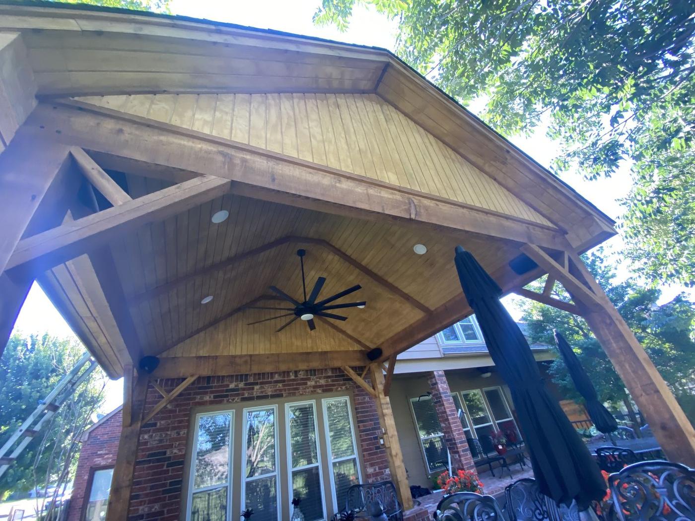 Cedar-beam covered patio with a stained wood ceiling
