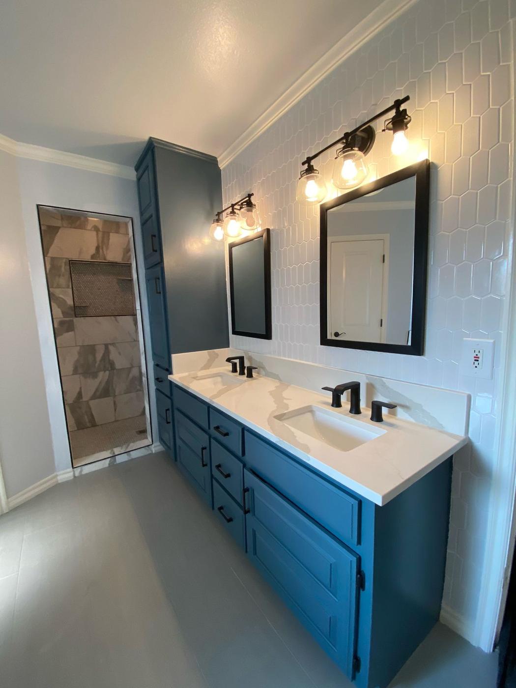 Remodeled master bathroom with a teal double vanity, quartz top and black fixtures