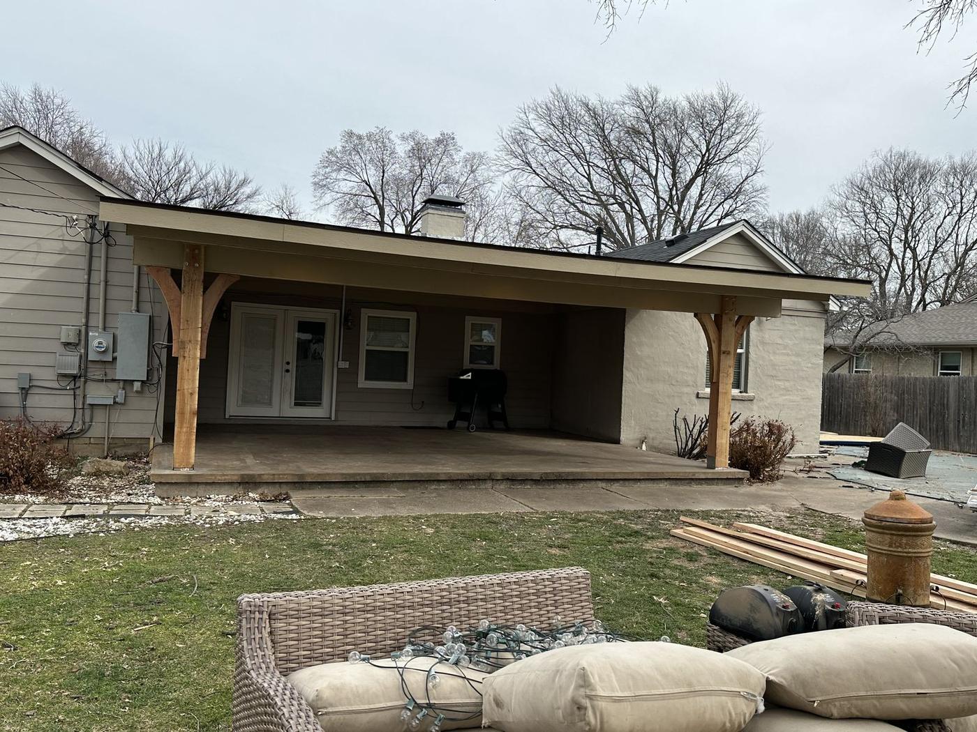Wide view of a backyard patio cover with cedar posts